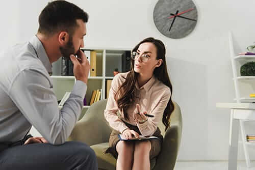 a man talks to a counselor in a heroin addiction rehab program